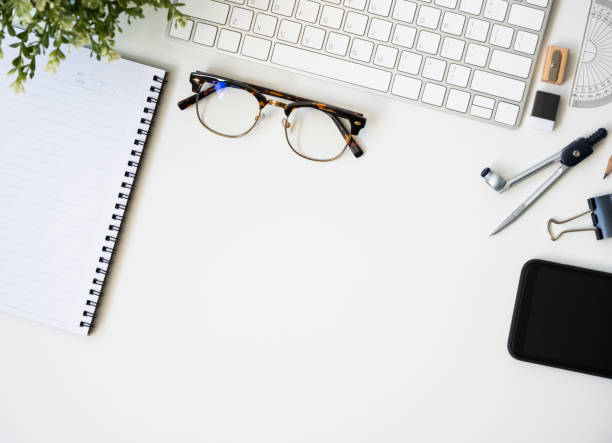 istock Top view table desk of office architect pencil, compasses tool, ruler, rubber, protractor grid, sharpener, glasses, smartphone, keyboard with copy space background. 1221392925