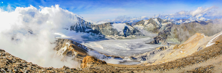 Dramatic panorama of a high alpine landscape in the swiss alps with approaching clouds and glacier on top of Barrhorn mountain at Kanton Wallis, the highest mountain in Switzerland accessible to hikers without special gear