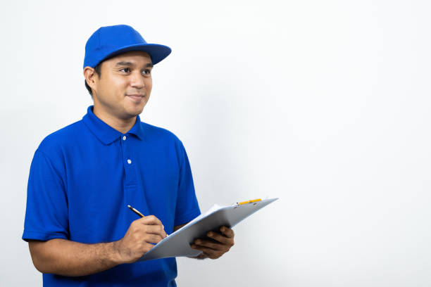 istock Asian Delivery man signing clipboard receipt of delivery package on isolated white background. 1221394708