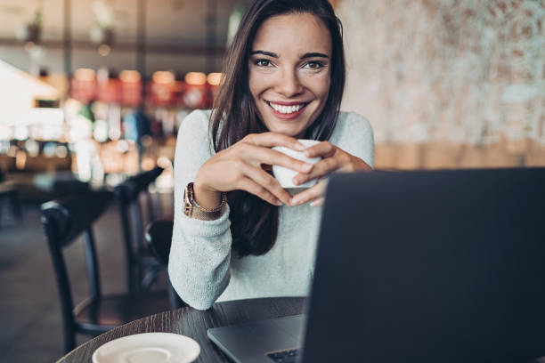 istock Cheerful young woman drinking coffee 1221397344