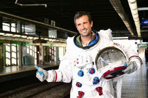An astronaut waits for the metro at the station