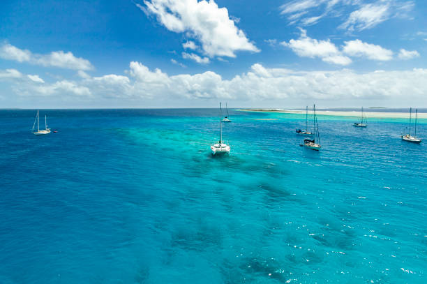sailing yachts at anchor in a turquois lagoon Sailing yacht anchoring in the shallow waters of suwarrow atoll, cook islands, polynesia, pacific ocean coral sea stock pictures, royalty-free photos & images