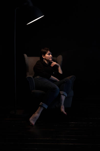 istock Pensive Woman Middle-aged Brunette in Dark Interior 1221401153