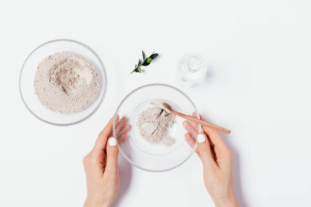 istock Woman's hands holding bowl of clay powder 1221402439