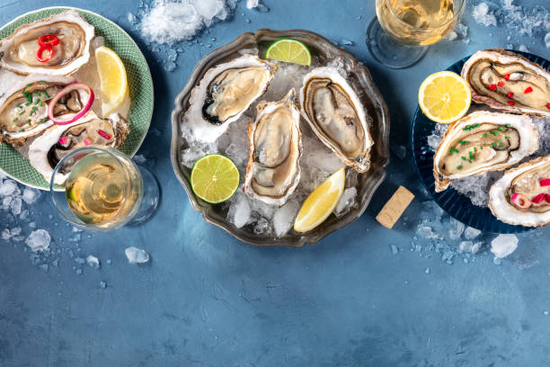 istock Oysters with various toppings, shot from above with wine, with lemon and lime, pepper, onion, with a place for text 1221402973