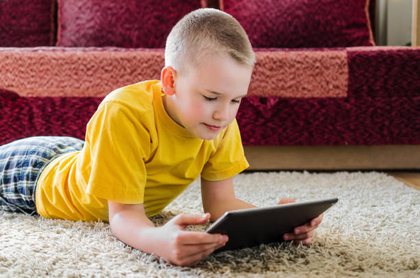 istock Distance learning online education. Schoolboy studying at home with digital tablet in hand and doing school homework. 1221403521