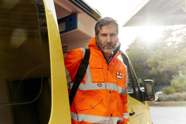 istock One emergency worker standing next to the ambulance and looking at camera. 1221406403