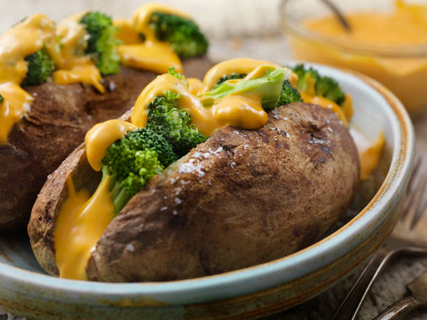 Cheese and Broccoli Stuffed Potatoes Cheese and Broccoli Stuffed Potatoes cheese sauce stock pictures, royalty-free photos & images