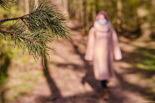 Woman in a park walks along the path after the end of isolation due to coronavirus, selective focus