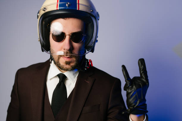 istock Biker man in suit wearing helmet and doing rock and roll horn sign 1221408541