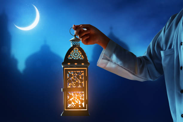 Muslim man holding arabic lantern, Ramadan kareem background stock photo