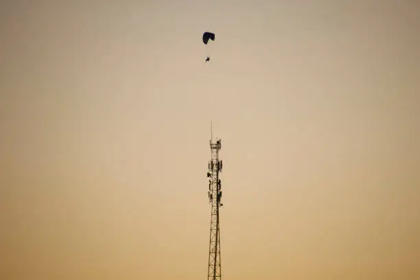 Photo of engine parachute flight near cell phone tower