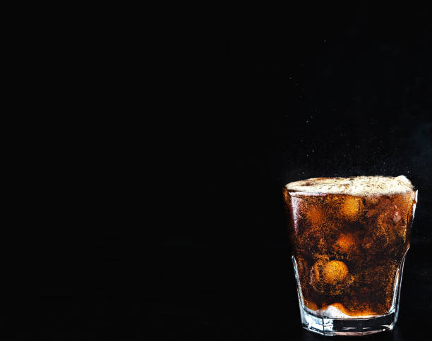 istock Cool, non-alcoholic, carbonated cola drink. Refreshing drink with sparkling water, a full glass with cola bubbles above the glass, the drink overflows. Dark background, close-up with copy space 1221414017
