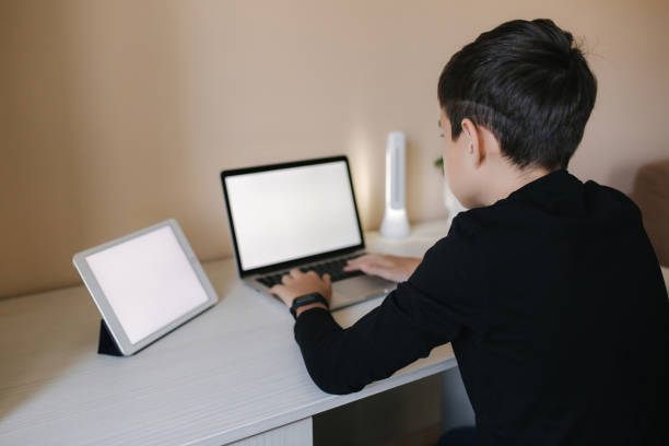 istock Teenage boy studying on laptop and watching something on tablet. Young boy use two device in same time. Working on laptop and tablet 1221418662