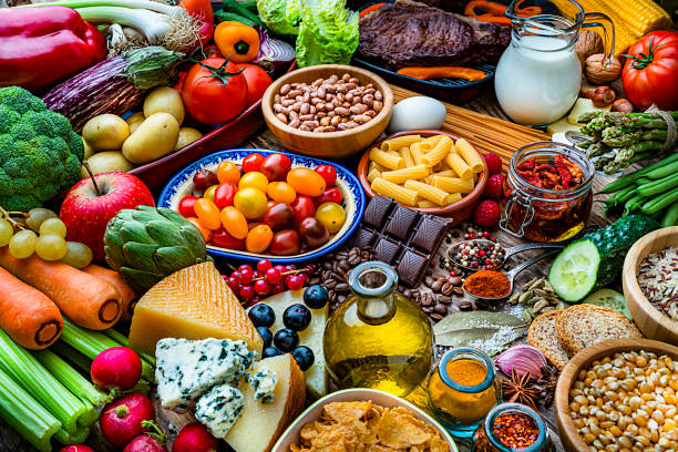 sfondi alimentari: tavolo pieno di grande varietà di cibo - artichoke food vegetable fruit foto e immagini stock