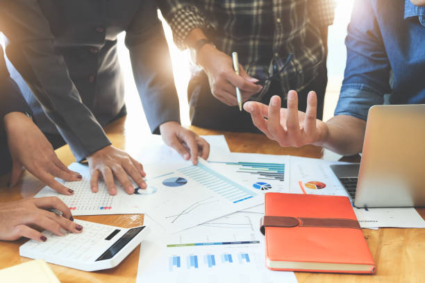 istock Business People Meeting using laptop computer, calculator,notebook,stock market chart paper for analysis Plans to improve quality next month. Conference Discussion Corporate Concept 1221418839