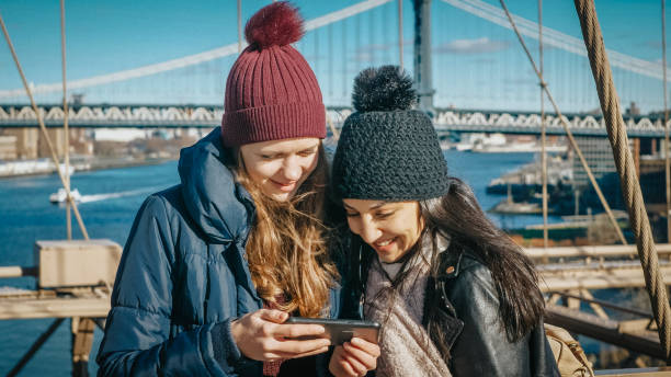 dwie dziewczyny chodzą po słynnym moście brooklińskim w nowym jorku - large transportation bridge famous place zdjęcia i obrazy z banku zdjęć