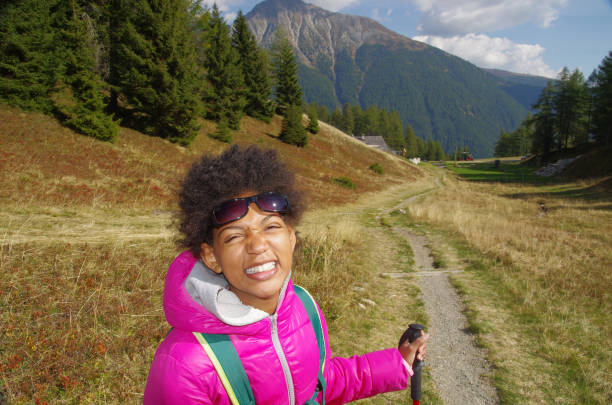 young girl smiles happy during alpine walk on mountain trails