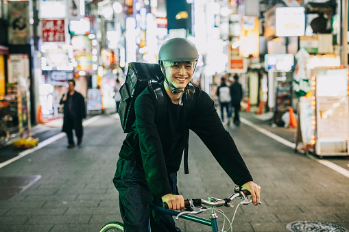 Portrait of Smiling Bike Courier working for food delivery app company.