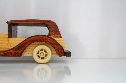 Back-end of a wooden model car on a white background