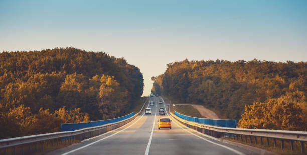 istock Traffic in high speed on a highway through rural landscape on sunset. 1221423704