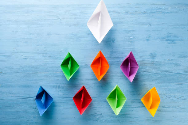 istock Colored paper boats on a blue background 1221424033
