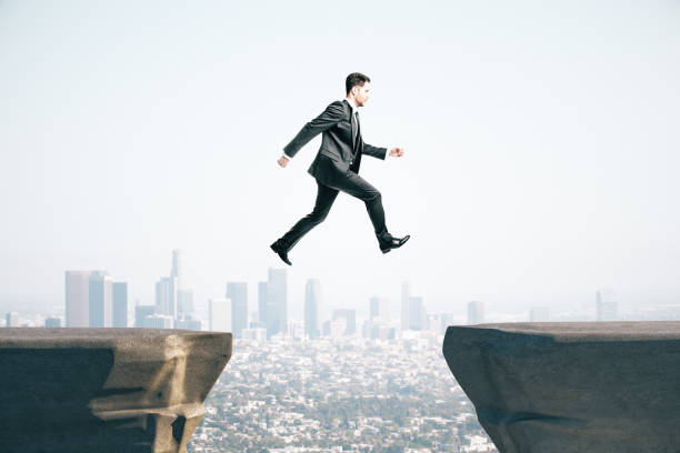 istock Businessman in suit jumping on mountain 1221424220