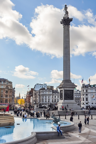London, UK - April 2018: People walking at Nelson's column on Trafalgar square
