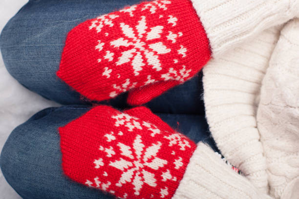 istock Hands in red mittens lying on woman knees 1221425353