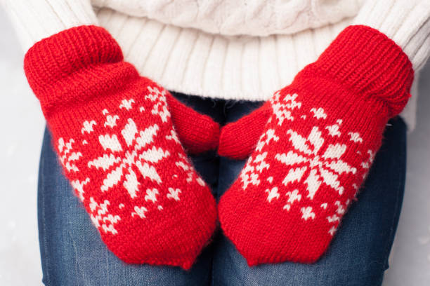 Hands in red mittens lying on woman knees