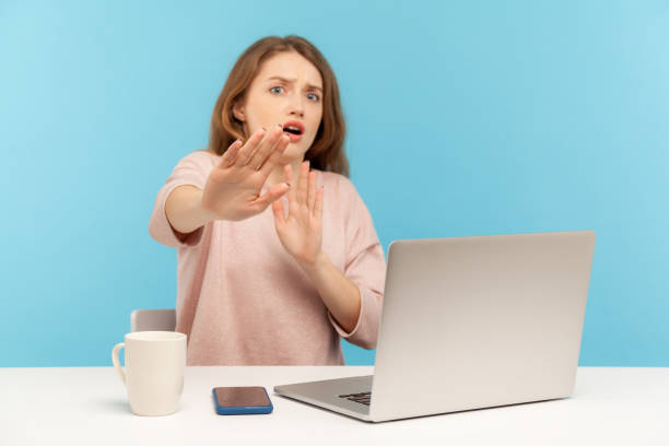 istock No, I'm scared! Frightened woman with shocked expression raising hands in stop gesture, defending herself, freaked out 1221426413