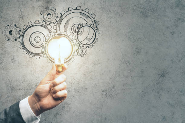 istock Hand holding lamp with drawing gears 1221427286