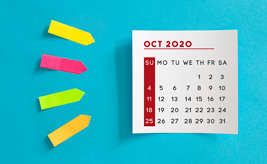 Calendar concept. October 2020 Calendar On The White note paper. Colored arrow-shaped sticky notes point to it. Horizontal composition with copy space.