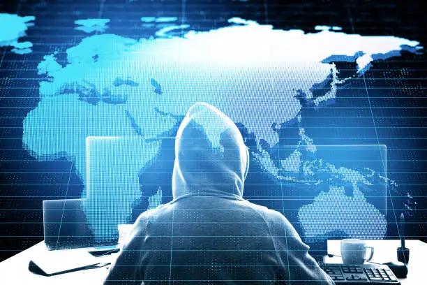 Photo of Hacker using computer with creative glowing world map