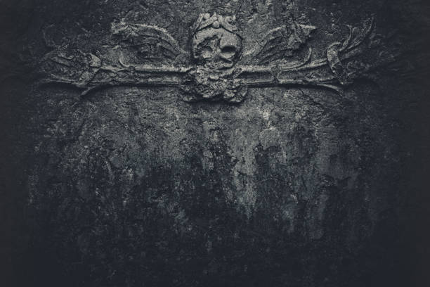 Dark skull background A dark background with a skull with wings decor. Detail from 18th century tombstone. place of burial photos stock pictures, royalty-free photos & images