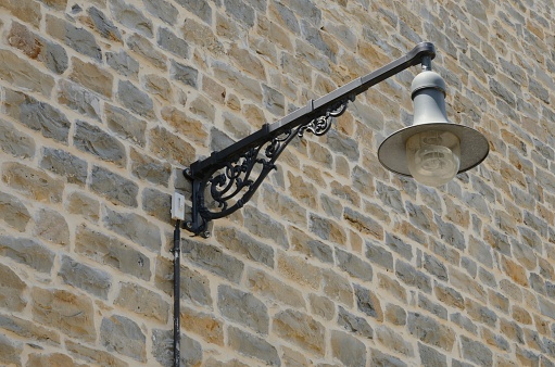 Streetlamp on brick wall in the old town of Pamplona, the capital of the Navarre Community, Spain.