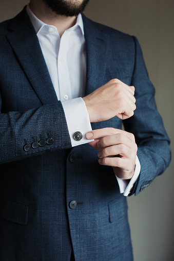 Close up of businessman wearing cufflinks. Elegant young fashion business man wearing suit.
