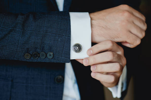 Close up of businessman wearing cufflinks. Elegant young fashion business man wearing suit. stock photo