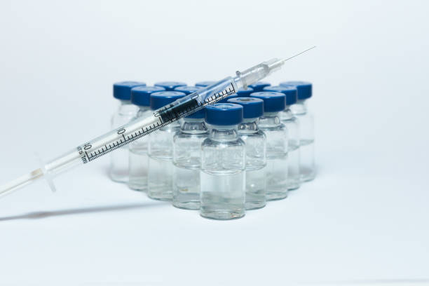 Glass medicine bottles with vaccine injection fluid with blue aluminium caps and syringe for vaccination, Coronavirus Covid-19 concept Glass medicine bottles with vaccine injection fluid with blue aluminium caps and syringe for vaccination, Coronavirus Covid-19 concept crista ampullaris photos stock pictures, royalty-free photos & images