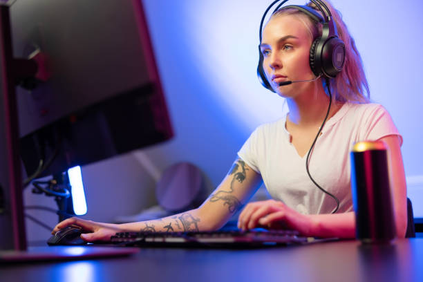 istock Professional gamer girl with headset play online multiplayer video game on PC 1221435242