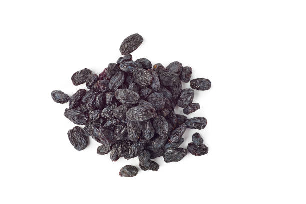 istock Heap of black raisins on white 1221435305