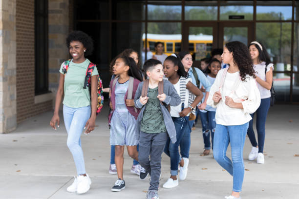 istock Diverse students talk as they leave school building 1221435684