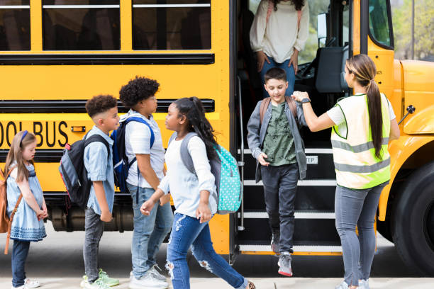 istock Bus driver helps children step off school bus 1221435699