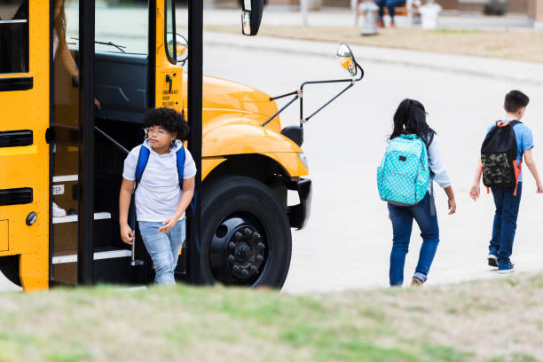 istock Mixed race schoolboy getting off of school bus 1221435791