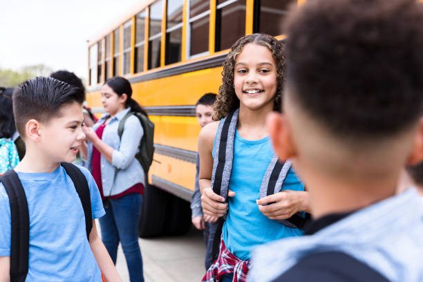 istock Happy middle schoolgirl talking with friends 1221435825