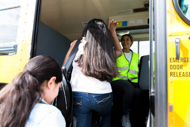 istock Schoolgirl board school bus 1221435876
