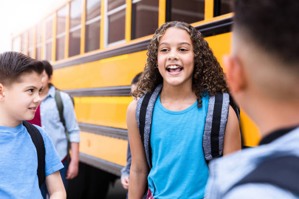 istock Mixed race schoolgirl talking with friends 1221435934