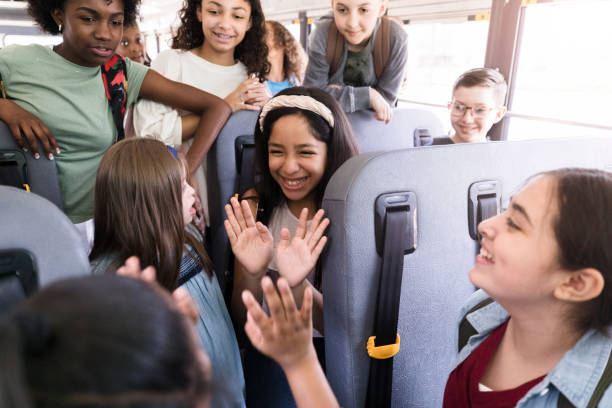 istock Girls laugh and play clapping game on school bus 1221436028