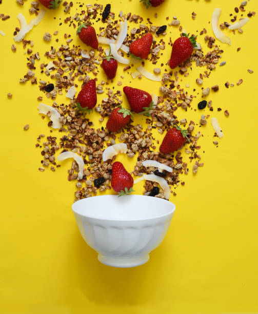 istock The process of making breakfast. Granola, coconut and strawberries on a yellow background. Liberation in the frame. 1221438178
