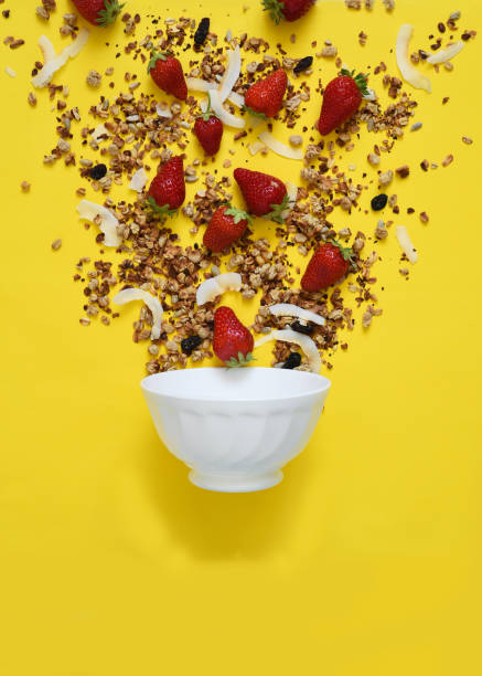 istock The process of making breakfast. Granola, coconut and strawberries on a yellow background. Liberation in the frame. 1221438248
